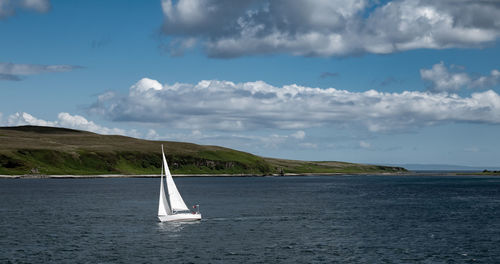 Sailboat sailing on sea against sky