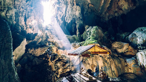 Sunlight streaming on buddha statue in cave