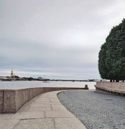 Footpath by sea against sky