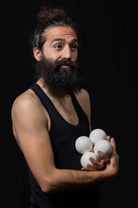 Portrait of man standing against black background