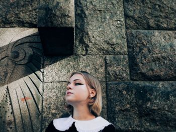 Portrait of a girl looking away against wall