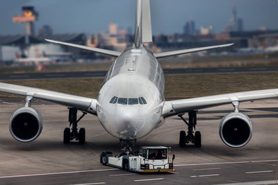 Airplane on airport runway against sky