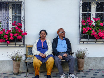 Portrait of happy friends sitting in flower pot