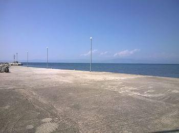 Scenic view of beach against clear blue sky