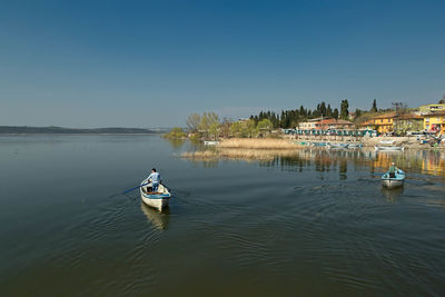 High angle view of boats moored in lake against clear sky