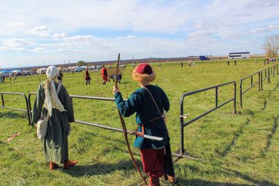 Rear view of man on field against sky