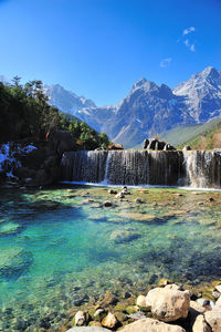 Scenic view of waterfall against sky