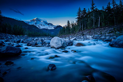 Surface level of water flowing in rocks against blue sky