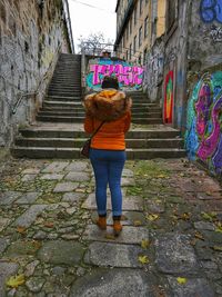 Rear view of woman standing on staircase