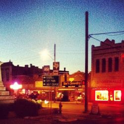 Illuminated street light against sky at night