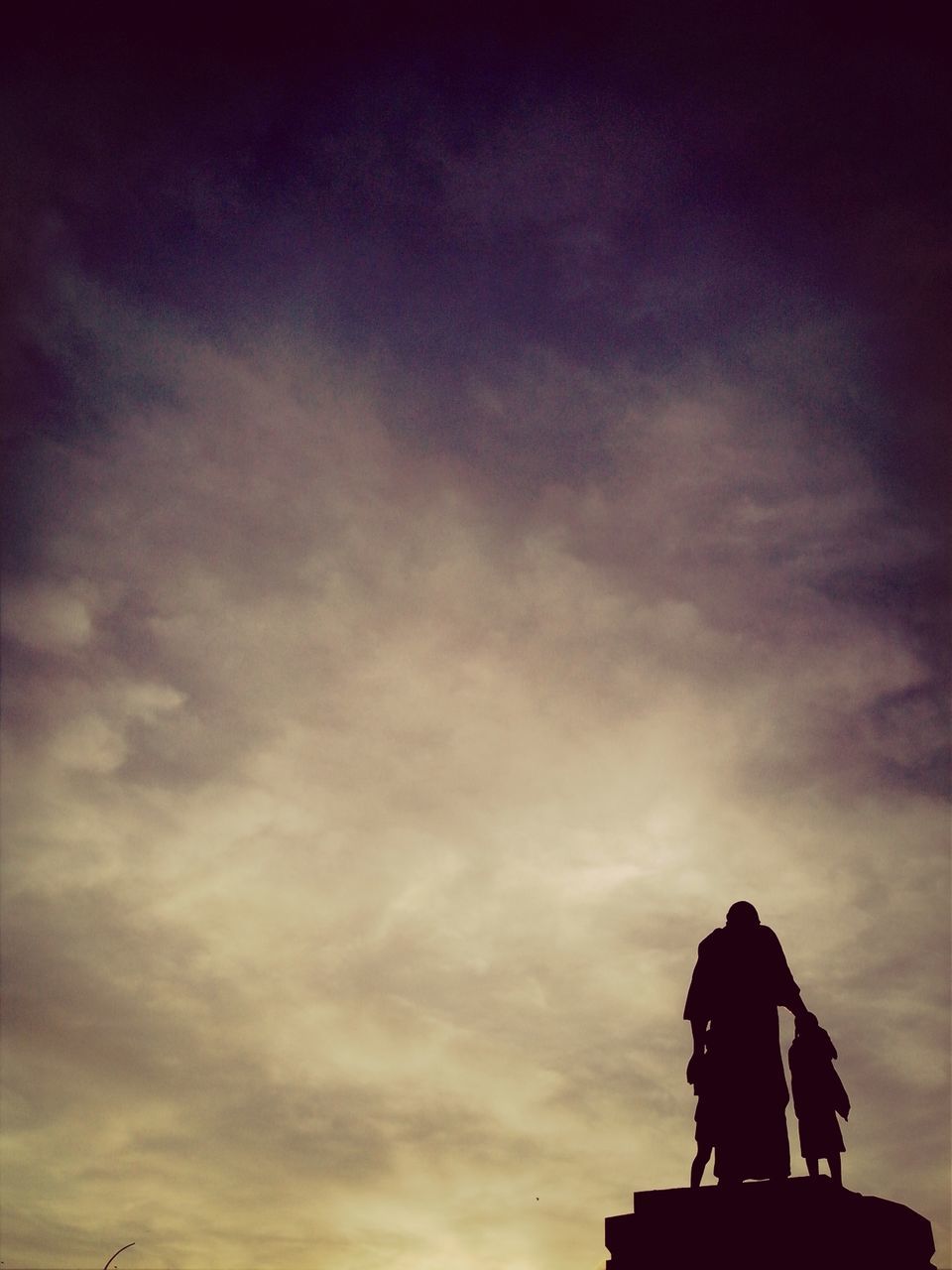 statue, sculpture, sky, low angle view, human representation, art, art and craft, cloud - sky, creativity, silhouette, animal representation, sunset, cloudy, cloud, outdoors, built structure, dusk, architecture