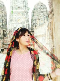 Young woman standing against historic building