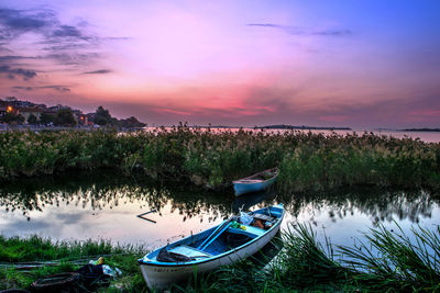 Boats in sea at sunset