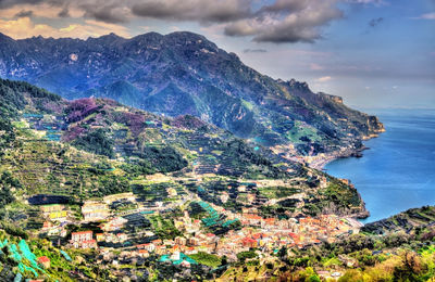 Aerial view of townscape by sea against sky