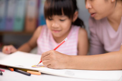 Close-up of boy drawing on book at home