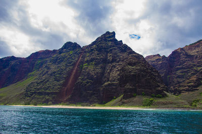 Scenic view of sea and mountains against sky