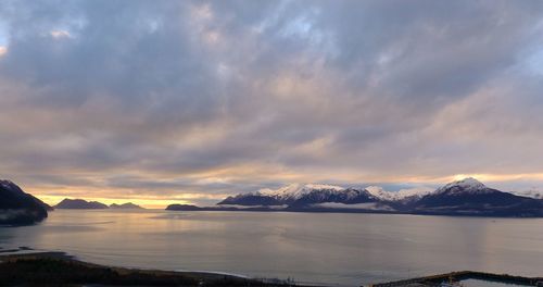 Scenic view of lake and mountains against sky during sunset