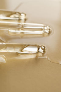 Pipettes with oil or serum on a golden background.