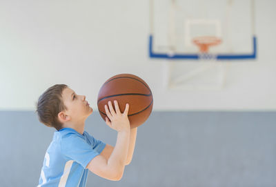 Boy playing basketball at court