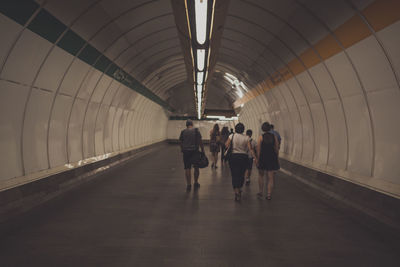 Rear view of people walking at subway station