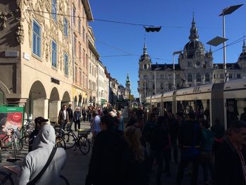 People on street by buildings in city