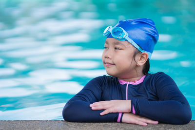 Happy children smiling cute little girl in sunglasses in swimming pool.