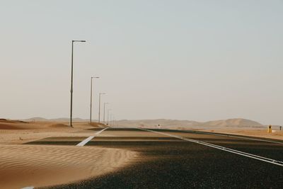Road by land against clear sky