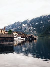 Scenic view of lake by buildings against sky