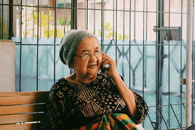 Mid adult woman looking away while sitting on window