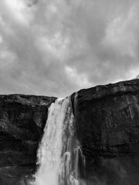 Scenic view of waterfall against sky