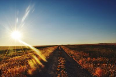 Road amidst field against sky