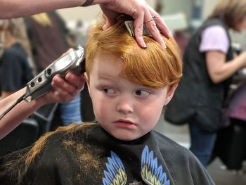 Suspicious boy receiving a haircut