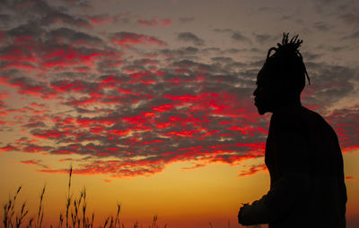 Silhouette man standing against orange sky