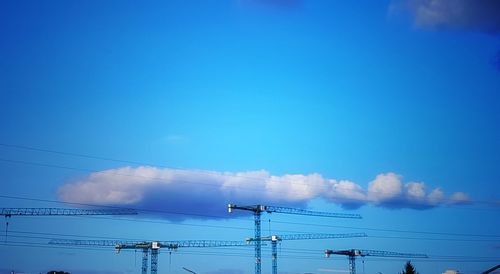 Low angle view of electricity pylon against blue sky