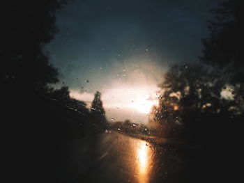 Close-up of wet car window during sunset