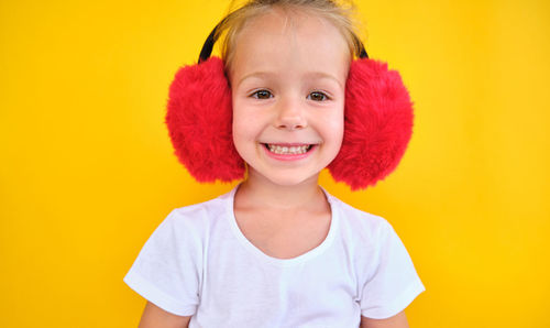 Portrait of cute girl against yellow background