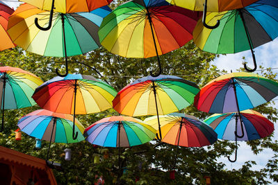 Low angle view of multi colored umbrellas hanging at market against sky