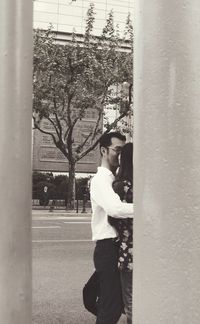 Side view of young man looking at camera