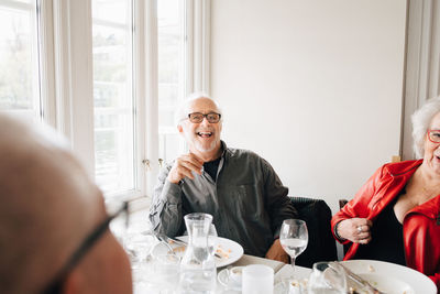 Happy senior friends enjoying while sitting in restaurant