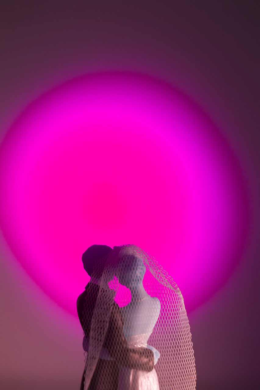 CLOSE-UP OF ILLUMINATED TOY AGAINST PINK WALL