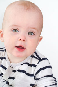 Close-up of cute baby boy against white background