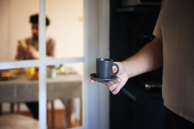 Man carrying cup of espresso at home