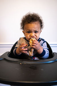 Portrait of baby boy eating chicken