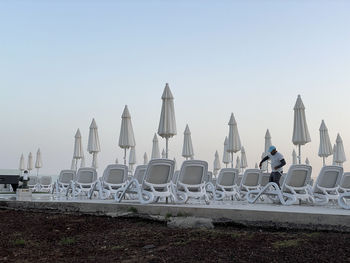 Chairs on beach against clear sky