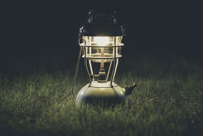Close-up of illuminated lamp on field