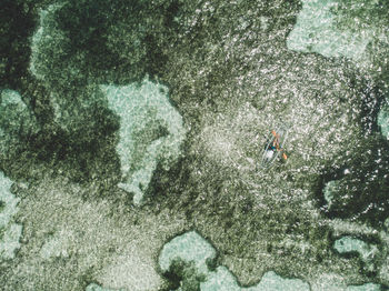 Aerial view of woman on inflatable boat in sea