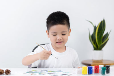 Boy holding ice cream on table