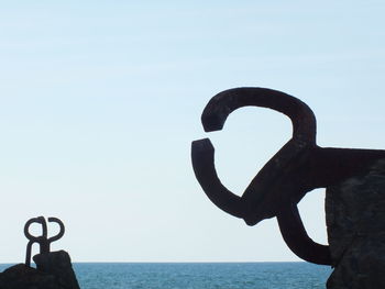 Close-up of statue against sea against clear sky