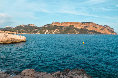 Scenic view of rocks in sea against sky