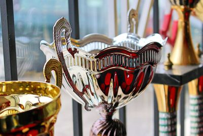 Close-up of trophies by window for sale